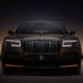 A sleek, black luxury Rolls-Royce Ghost is prominently displayed against a dark gradient background. The car features a bold vertical grille with the Rolls-Royce emblem, illuminated rectangular headlights, and a striking, elegant design that exudes sophistication and power. | MAKE1M