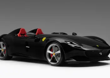 A sleek black Ferrari Monza SP2 sports car with red interior, seen from a three-quarter front view. The car features a low-profile design, large silver wheels with red brake calipers, Ferrari logo on the side, and an open-top, two-seat configuration. | MAKE1M