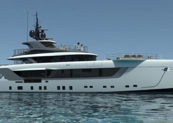 A sleek, modern luxury yacht from one of the top luxury yacht brands floats on calm, clear waters under a bright, blue sky. The yacht has a white and dark gray exterior with multiple decks, large windows, and elegant design features. A few people are visible on the upper deck. | MAKE1M