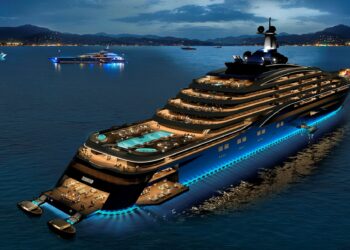 A luxurious yacht illuminated at night, featuring multiple decks with pools, seating areas, and a helicopter pad. This epitome of luxury yachts is anchored in calm waters with two smaller yachts in the background, all under a twilight sky with stars beginning to emerge. | MAKE1M
