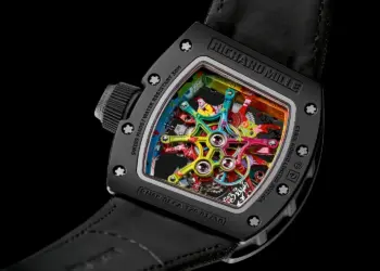 Close-up of the back of a Richard Mille RM 68-01 watch, showcasing its intricate and colorful mechanics through a transparent caseback. The vibrant gears and components contrast with the black case and leather strap, highlighting the luxury watch's elaborate and artistic design. | MAKE1M
