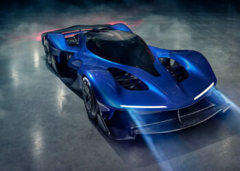 A sleek, futuristic blue hypercar reminiscent of the Red Bull RB17 with a streamlined design and prominent LED headlights is showcased in a dimly lit environment. The car has a low profile, large air vents, and an aerodynamic rear wing. The background features a misty, reflective surface. | MAKE1M