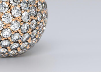 A close-up of luxurious jewelry: a spherical object encrusted with numerous sparkling diamonds set in gold, positioned toward the left with a smooth light grey background on the right. | MAKE1M
