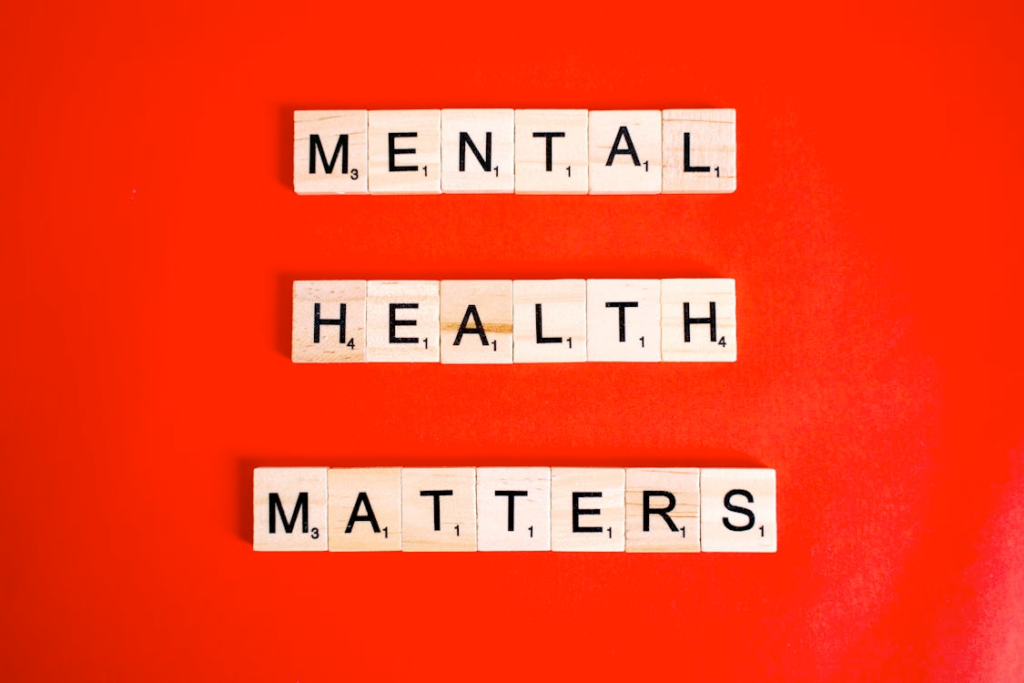 Scrabble tiles spell out "MENTAL HEALTH MATTERS" against a bright red background. | MAKE1M